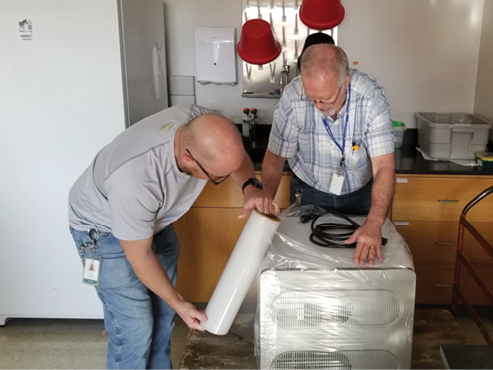 Oklahoma Medical Research Foundation lab manager Sean Turner and  biomed shop supervisor Mike Austin prepare equipment to move to OU Medicine for the Covid-19 testing lab 